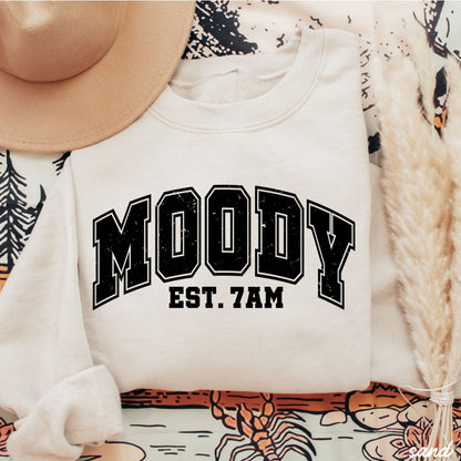Moody 7am Sweatshirt 7 Colors S-3X displayed on a patterned background with hat and decor.